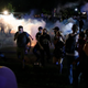 Protestors run for cover as police shoot tear gas in an effort to disperse the crowd outside the County Courthouse during demonstrations against the shooting of Jacob Blake in Kenosha, Wisconsin on August 25, 2020.